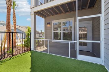 Covered balcony with artificial turf and sliding glass door